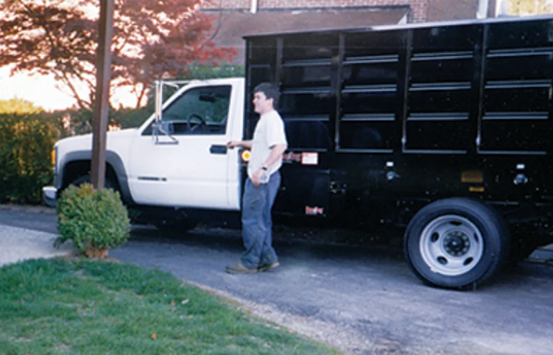 Brendan Gibbons standing beside his first company truck in 1999